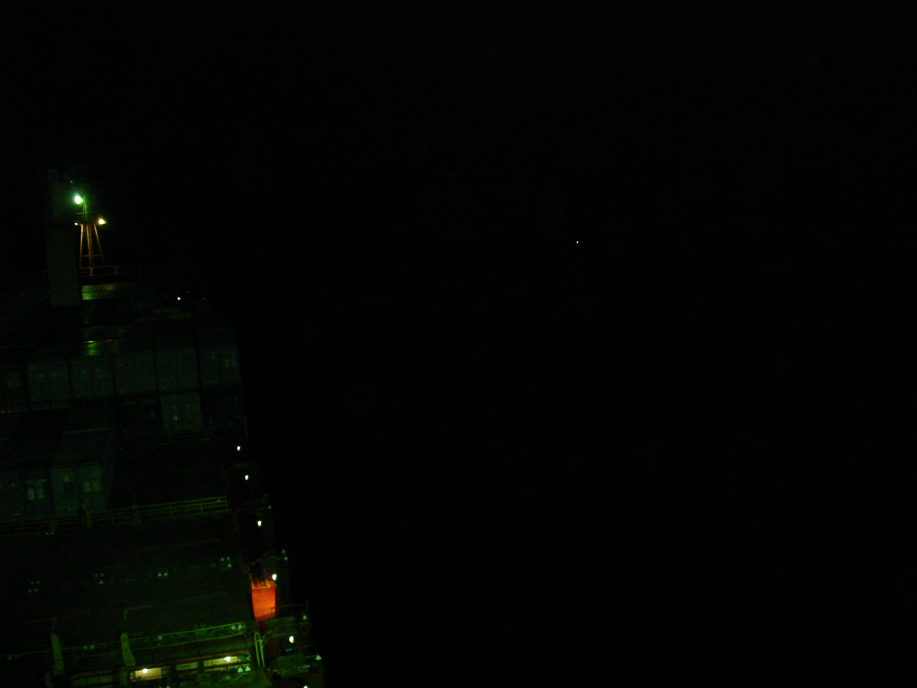 Pirate skiff approaching the Maersk Alabama, photographed from the bridge on the night of April 8, 2009. The light at center-right is the attacking vessel.
