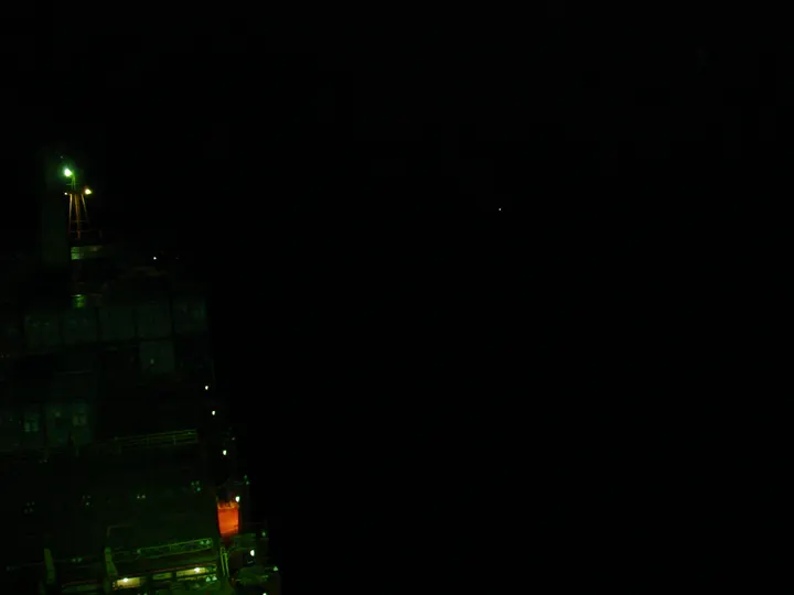 Pirate skiff approaching the Maersk Alabama, photographed from the bridge on the night of April 8, 2009. The light at center-right is the attacking vessel.