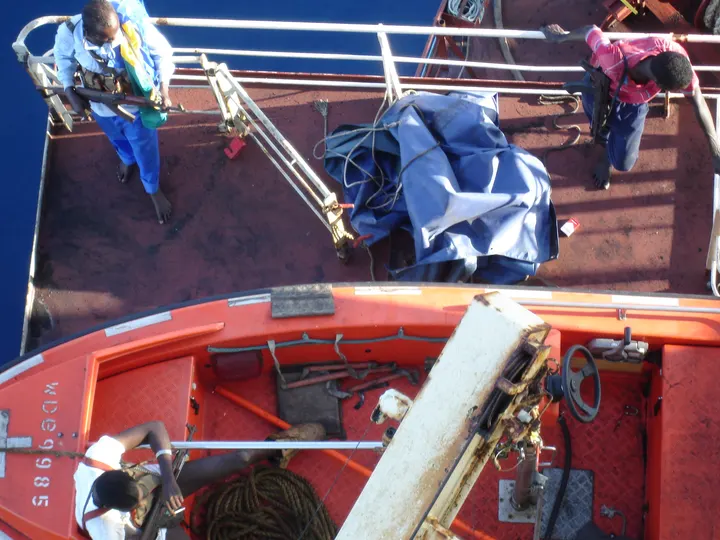 Somali pirates on the deck of the Maersk Alabama, April 8, 2009, photographed from the ship's superstructure during departure. At least one is visibly armed.