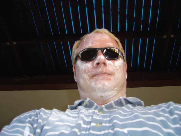 Mike Long, merchant seaman, covered in Thai New Year face powder